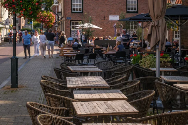 Charming outdoor cafe with stylish seating on a sunny day, perfect for a relaxing afternoon. Horeca dichtbij: hoe u het horeca-aanbod in uw buurt verkent