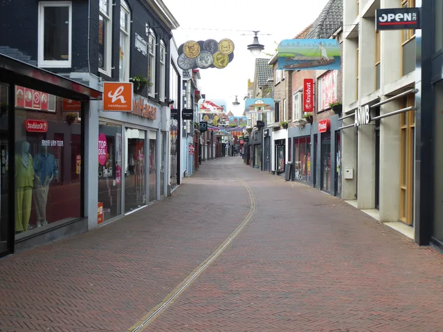 Quiet European shopping street with closed stores and empty brick path. Nieuw geopend in de buurt: hoe u openingen en verhuizingen bijhoudt